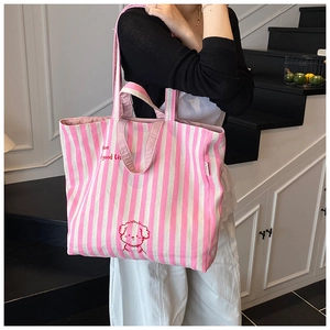 Detail of pink striped canvas tote bag with red puppy embroidery and cursive script lettering