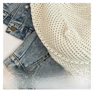 Close-up of beige crochet knit bag featuring a honeycomb hollow pattern and fine texture