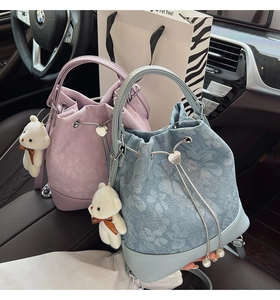 Detail of floral jacquard bucket bags in lavender and blue with cute bear charms