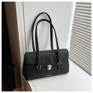 Close-up of black lychee grain texture with silver twist lock on armpit shoulder bag