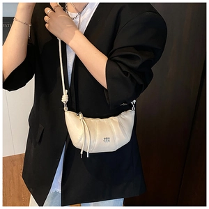 Detail of off-white croissant bag with adjustable knotted strap and COIN ZDN logo
