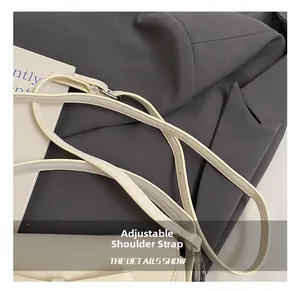 Détail de la bandoulière réglable en cuir avec boucle argentée sur sacoche crème