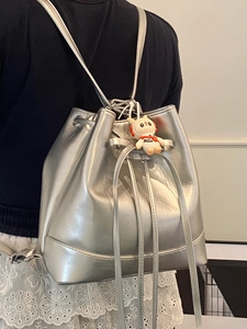 Silver metallic bucket backpack with drawstring closure and cute white plush doll accessory