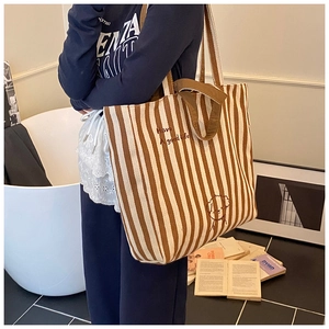 Detail of canvas tote bag featuring brown stripes and cute embroidered dog pattern