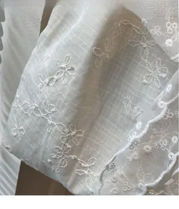 Close-up of intricate white lace floral embroidery on high-quality fabric handbag