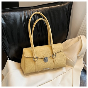 Detail of light yellow lychee grain leather handbag with silver twist lock and hardware