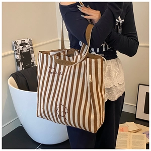 Detail of striped canvas tote bag featuring dog embroidery and Have A good life text