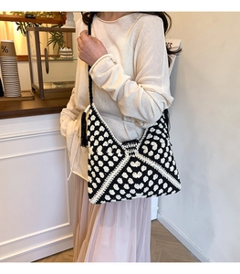 Dettaglio del motivo all'uncinetto bianco e nero con elegante nappa lunga sulla borsa