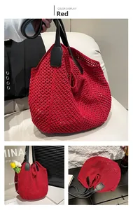 Detail of red crochet tote bag with open-knit mesh pattern and black leather handles