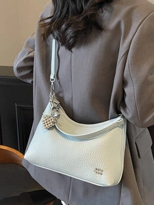 Chic light grey pebbled leather hobo bag with a pearl heart charm and slim strap
