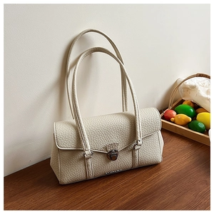 Close-up of cream white underarm bag with lychee texture and metal twist lock detail