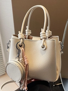 Borsa a secchiello in pelle bianca con manico annodato e ciondolo con nappa rosa
