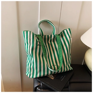 Detail of green and white striped canvas tote bag featuring Snoopy graphic print