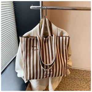 Close-up of striped canvas tote bag with dog embroidery and versatile shoulder straps
