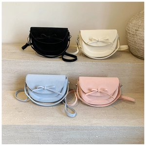Vue détaillée de petits sacs de selle en quatre couleurs avec nœuds sur un escalier