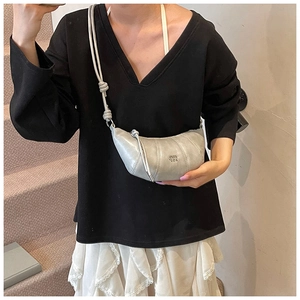 Detail of silver crescent leather bag with pleated design and knotted shoulder strap