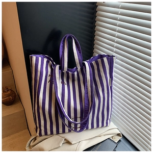 Detail shot of purple striped canvas tote bag with smiley embroidery and durable texture