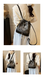 Detail of floral bucket bag with drawstring closure, metal chain, and plush bear charm