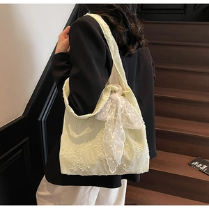 Detail of the elegant floral embroidery and large lace bow on the shoulder bag strap