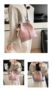 Detail of pink college style bucket bag with heart metal buckle and pearl charm accessory