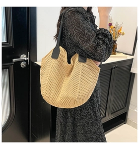 Close-up of beige woven texture with contrast black leather handle on tote bag