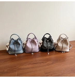 Detail of four jacquard bucket bags in blue, purple, black, and beige with floral texture