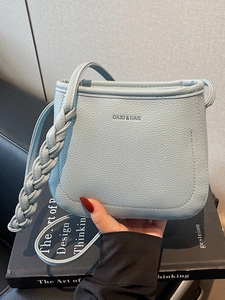 Minimalist light blue lychee leather bucket bag with woven strap detail for women