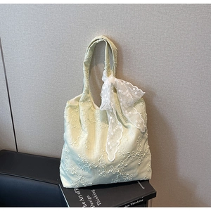 Close-up of mint green floral embroidery tote bag with lace bow handle detail