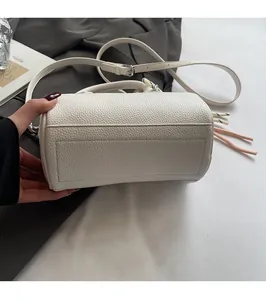 Detail of the high-quality litchi grain texture and reinforced stitching on white cylinder bag