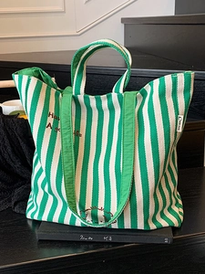 Green and white striped canvas tote bag with dog embroidery and top handles