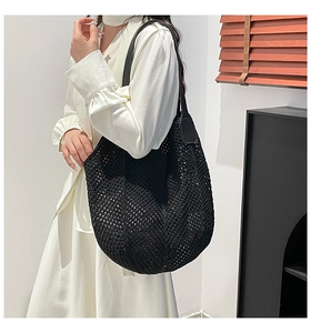 Detail of a black woven tote bag showing the intricate hollow out knit texture and soft material