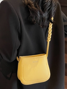 Bright yellow saddle bucket bag with thick braided strap and leather texture for women