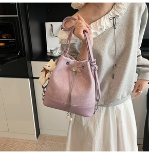 Detail of lavender bucket bag with heart buckle, pearl charm and cute bear keychain