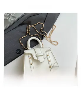 Detailansicht der cremeweißen PU-Lederhandtasche mit goldenen Nieten und Perlenkette