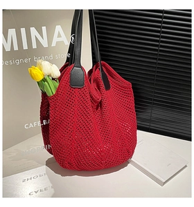 Detail of red crochet knit tote bag showing intricate mesh pattern and black leather straps