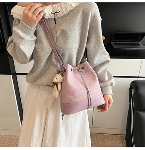 Detail of lavender drawstring bucket bag with floral jacquard texture and bear charm