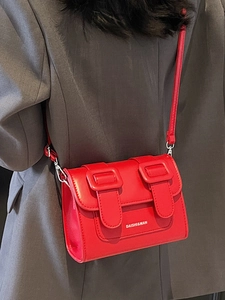 Chic red faux leather satchel bag with double buckle straps and slim shoulder strap