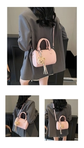 Pink lychee textured Boston bag with plush bear charm and detachable shoulder strap