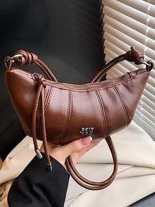 Fashionable dark brown leather dumpling bag with silver logo and knot shoulder strap detail