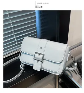Vue détaillée du sac bandoulière en cuir bleu clair avec une grande boucle métallique