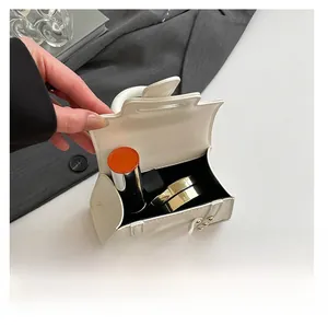 Detailansicht der weißen Mini-Lederhandtasche mit Platz für Lippenstift und Puderquaste