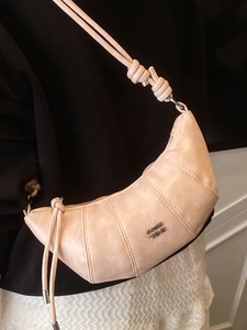 Chic dumpling-shaped crossbody crescent bag in soft nude pink with knot shoulder strap detail