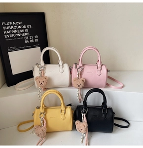 Detailed view of cylinders handbag collection in various colors with cute bear pendants