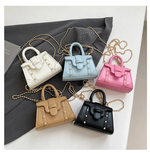Draufsicht auf stilvolle Mini-Quadrat-Handtaschen in fünf Farben mit goldenen Kettenriemen