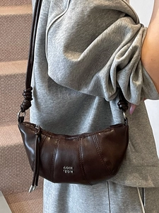 Dark brown pleated leather dumpling bag with COIN 2DN logo on a stylish crossbody strap