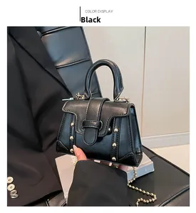 Detail der schwarzen Ledertasche mit goldenen Nieten und schicker Perlenkette