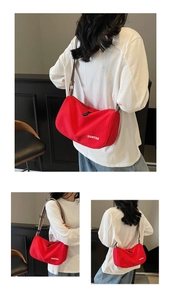 Detail of red cylinder crossbody bag with striped strap and OOMTAO branding logo