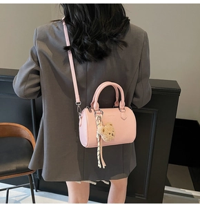 Detailed view of pink cylinder Boston bag with lychee pattern and cute bear charm
