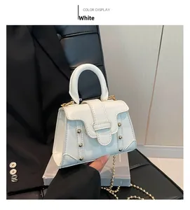 Detailaufnahme einer weißen Mini-Quadratasche mit Goldnieten und rundem Griff