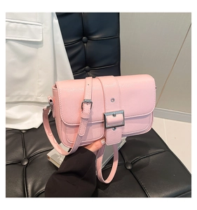 Détail du sac à bandoulière rose en similicuir avec texture litchi et boucle en argent